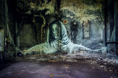 Ein großes Wandbild einer Frau in einem schmutzigen Raum