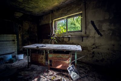 Ein schmutziges Zimmer mit einem gebrochenen Waschbecken und einem Fenster