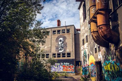 Ein Graffiti überdachtes Gebäude mit einem großen Wandbild an der Seite