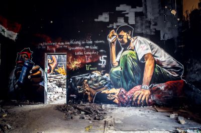 Ein Mann malt ein Wandbild an einer Wand