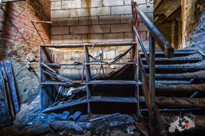 Ein Zimmer mit einem Haufen Schutt und einem kaputten Stuhl