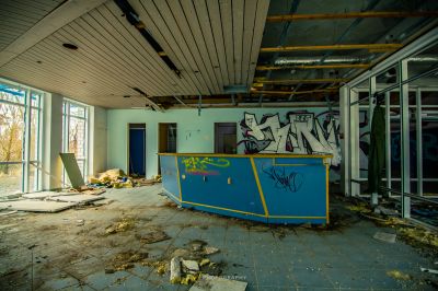 Ein Raum mit einem blauen Tresen und Graffiti an den Wänden