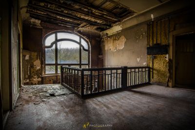 Ein Zimmer mit einem Geländer und einem Fenster