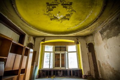 Ein Zimmer mit einer gelben Decke und einem Fenster