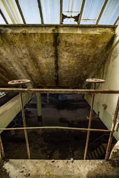 Ein schmutziges Zimmer mit einem Metallgeländer und einem Fenster