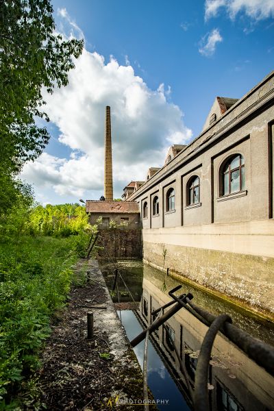 Ein Kanal mit einem Backsteingebäude und einem Backsteinkamin