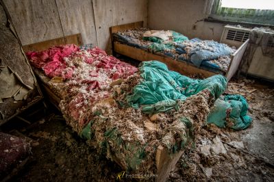 Ein chaotischer Raum mit einem Bett und einem Haufen Kleidung