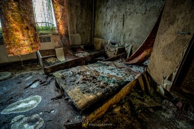 Ein Bett in einem Zimmer mit einem zerbrochenen Fenster