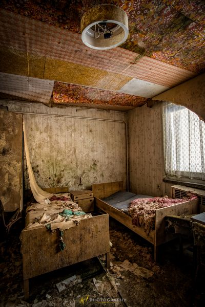 Ein Zimmer mit einem Bett und einer Decke mit einer gebrochenen Decke