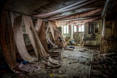 Ein Zimmer mit einem Stuhl und einem kaputten Fenster