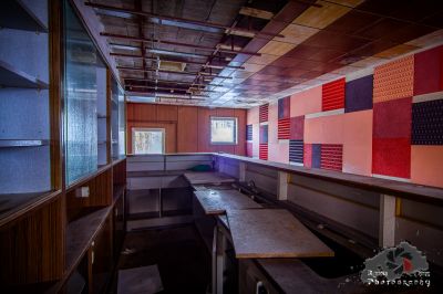 Ein Zimmer mit einem Schreibtisch und einer Wand aus bunten Fliesen