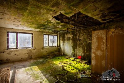 Ein Zimmer mit einer kaputten Decke und einer kaputten Tür