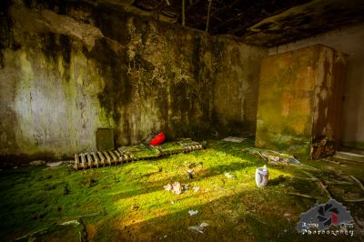 Ein Zimmer mit einem Stuhl und einem roten Regenschirm