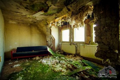 Ein Zimmer mit einer Couch und einem Blumenstrauß