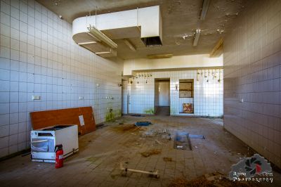 Ein Zimmer mit viel Schutt und einem Kühlschrank