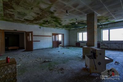 Ein Zimmer mit einer kaputten Decke und einem kaputten Kühlschrank