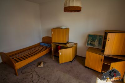 Ein Zimmer mit einem Bett, einem Schreibtisch und einem Fernseher