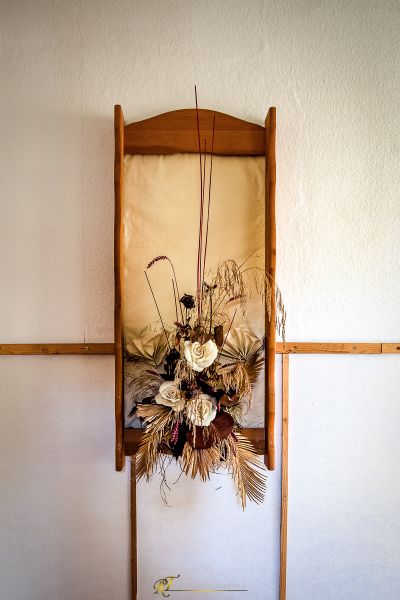 Eine Vase von Blumen hängt an einer Wand