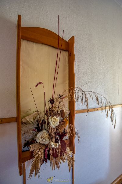 Eine Vase der Blumen ist auf einem hölzernen Stuhl