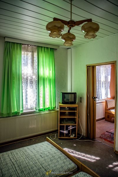 Ein Schlafzimmer mit einem Bett, einem Fernseher und einem Ventilator