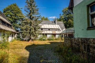 Eine kleine cobbed Straße mit einem Haus im Hintergrund