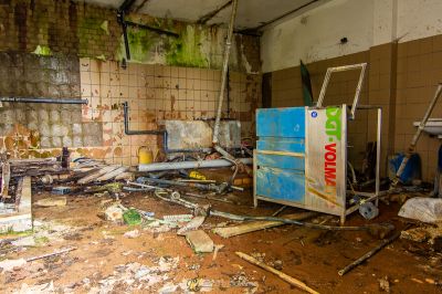 Eine schmutzige Küche mit einem kaputten Kühlschrank und einem kaputten Kühlschrank