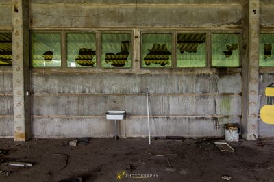 Ein Zimmer mit einem kaputten Fenster und einer kaputten Toilette