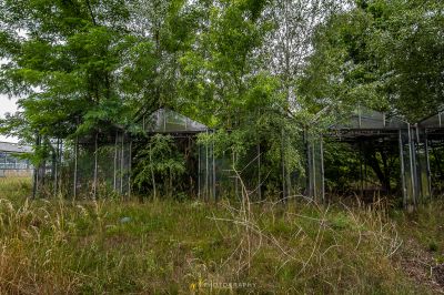 Ein eingezäunter Bereich mit einem Gebäude im Hintergrund