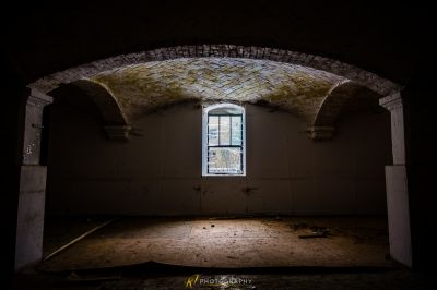 Ein Zimmer mit einem Fenster und einer Ziegelwand