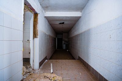 Ein langer Flur mit gefliestem Boden und Wänden