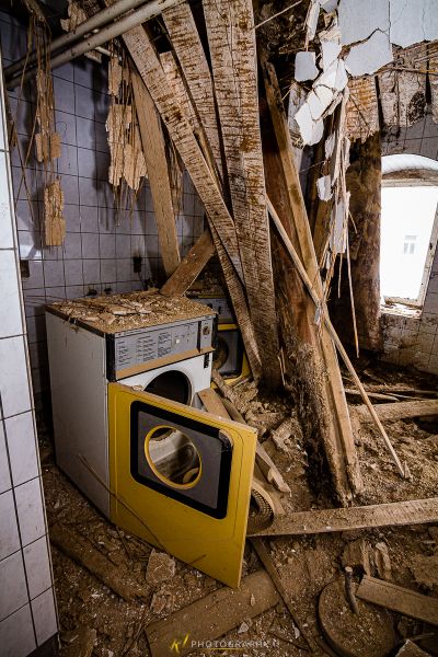 Eine schmutzige Küche mit einer kaputten Waschmaschine