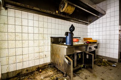 Eine schmutzige Küche mit Herd und Waschbecken