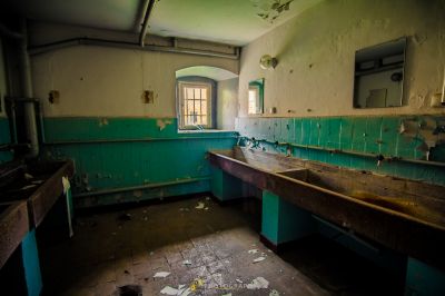 Ein schmutziges Badezimmer mit Waschbecken und Fenster