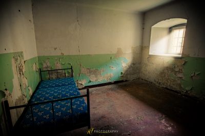 Ein Bett in einem Zimmer mit schälender Farbe