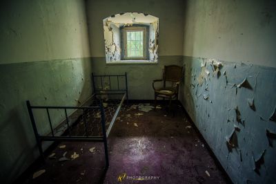 Ein Zimmer mit einem Bett und einem Stuhl