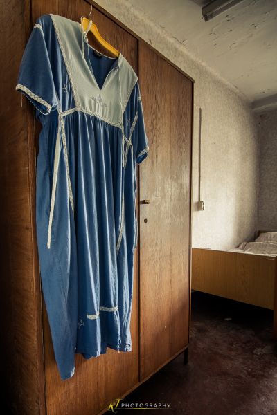 Ein blaues Kleid, das an einer hölzernen Tür hängt