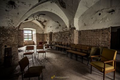 Ein Zimmer mit einem Haufen Stühle und einem Kamin