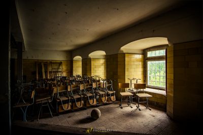 Ein Zimmer mit einem Haufen Stühle und einem Fenster