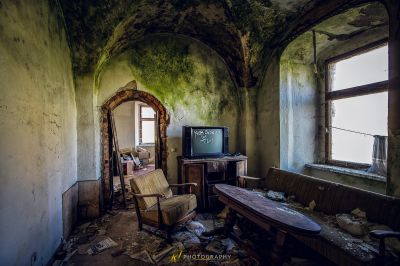 Ein Zimmer mit Stuhl und Fernseher