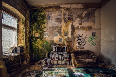 Ein Zimmer mit einem Haufen Bücher und einem Stuhl