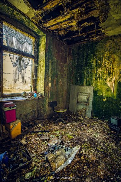 Ein Zimmer mit einem kaputten Fenster und einer kaputten Toilette