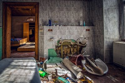 Ein Zimmer mit einem Bett und einer kaputten Toilette