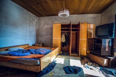 Ein chaotisches Schlafzimmer mit einem Bett und einem Fernseher