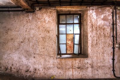 Ein Fenster in einem schmutzigen Raum mit einer Wand
