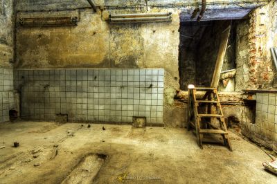 Ein schmutziges Zimmer mit einem Stuhl und einem kaputten Fenster