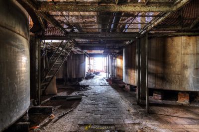 Einen langen Flur mit einem Ziegelboden und einer Metallstruktur