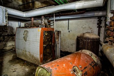 Ein Raum mit einem Haufen Pfeifen und einem großen orangefarbenen Objekt