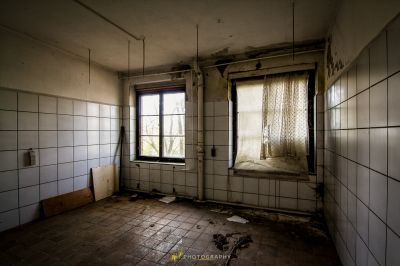 Ein Zimmer mit Fenster und Fliesenboden