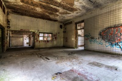 Ein Raum mit Graffiti an den Wänden und einem gefliesten Boden