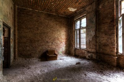 Ein Zimmer mit einem Stuhl und einer Ziegelwand